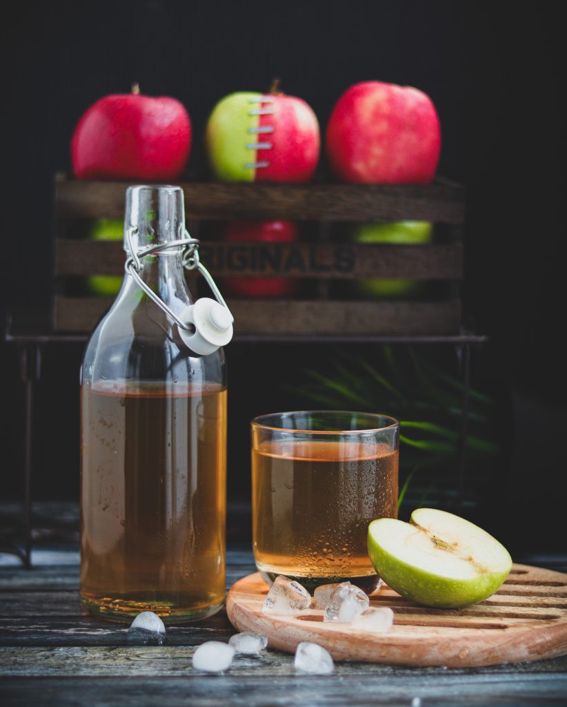 bottle of Apple Cider Vinegar with glass and apple